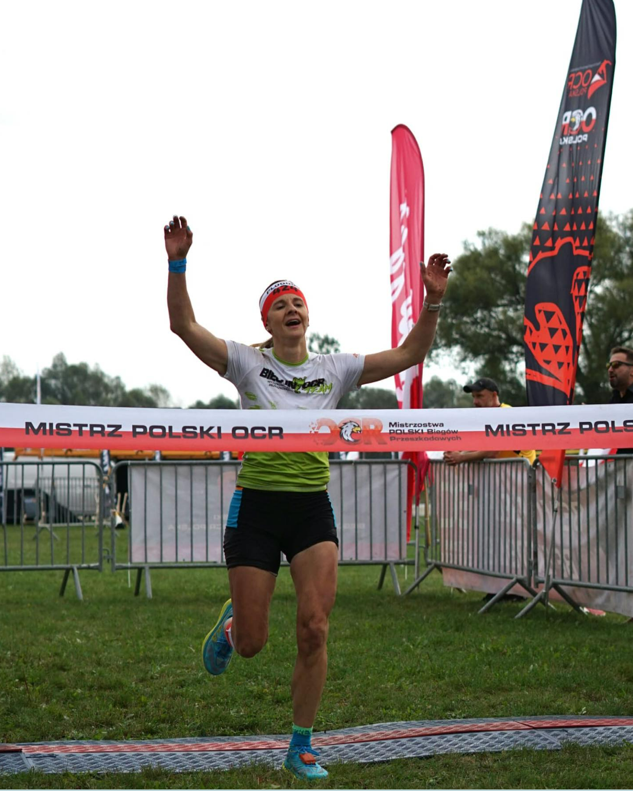 zawodniczka wbiegająca na metę z uniesionymi rękoma